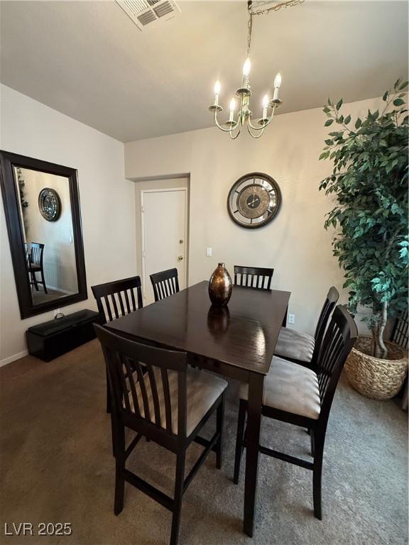 dining space with a chandelier and dark carpet