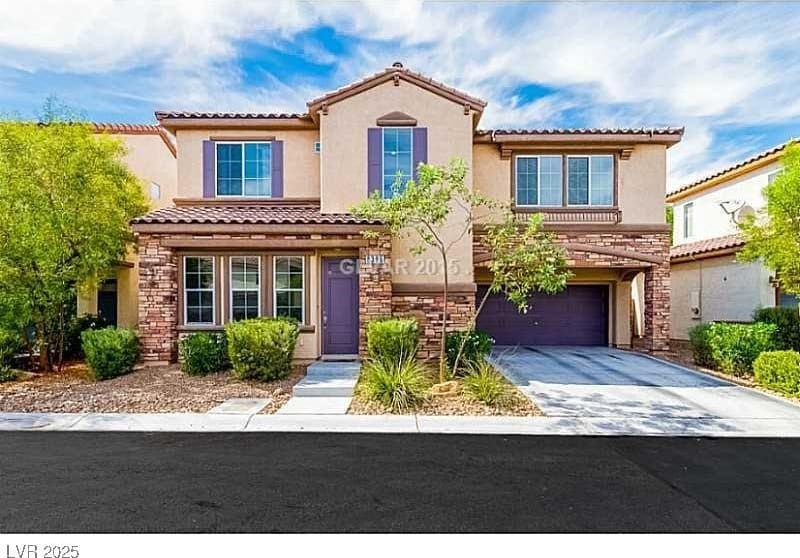 mediterranean / spanish home featuring an attached garage, stone siding, concrete driveway, and stucco siding