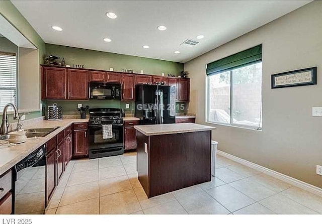 kitchen with visible vents, a center island, light countertops, black appliances, and a sink