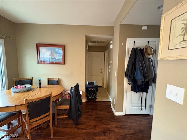 dining room featuring dark wood finished floors, baseboards, and visible vents