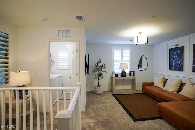 living room featuring carpet floors and washing machine and clothes dryer