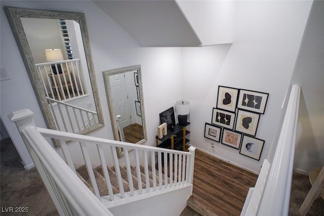 stairs featuring lofted ceiling and hardwood / wood-style floors