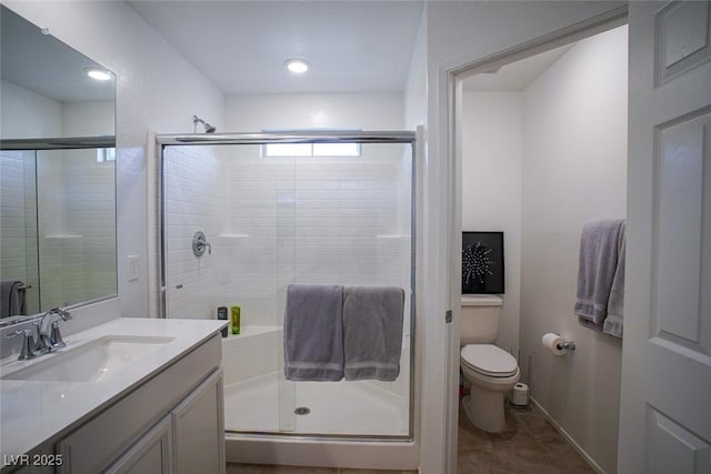 bathroom featuring walk in shower, vanity, toilet, and tile patterned flooring