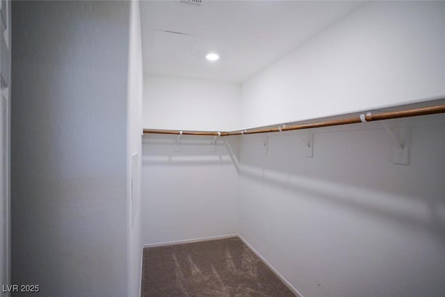 walk in closet featuring dark colored carpet