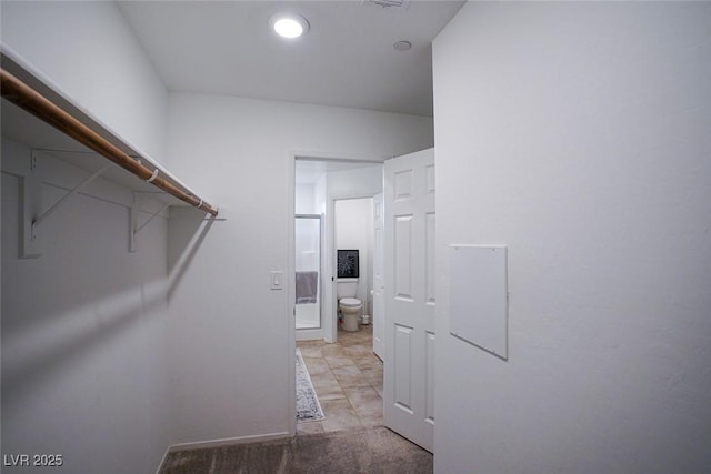 walk in closet featuring light colored carpet