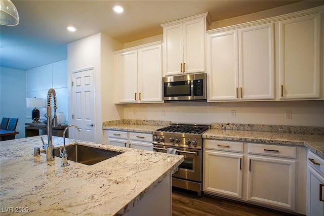 kitchen featuring stainless steel appliances, white cabinetry, light stone countertops, and dark hardwood / wood-style floors