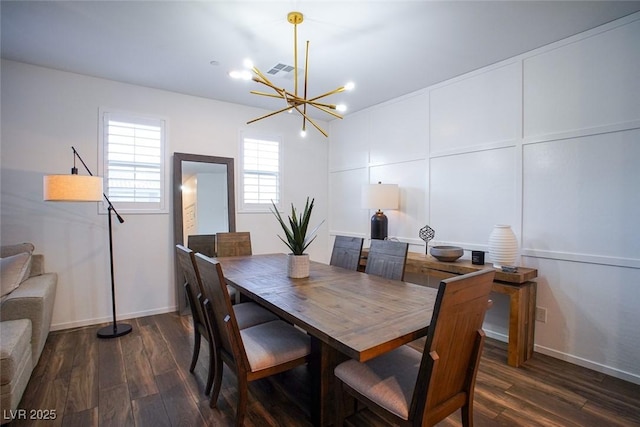 dining space with dark hardwood / wood-style floors and a notable chandelier