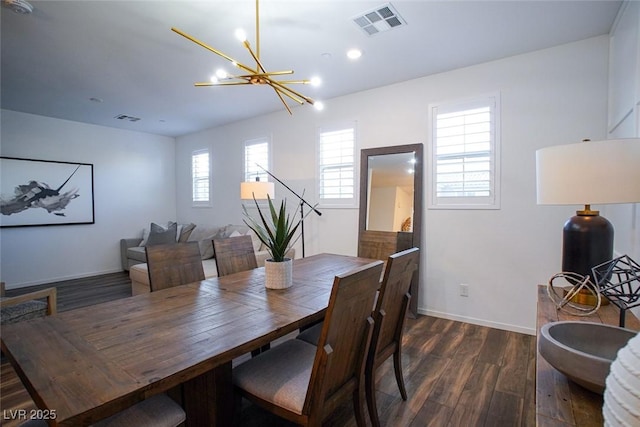 dining area with dark wood-type flooring and a chandelier