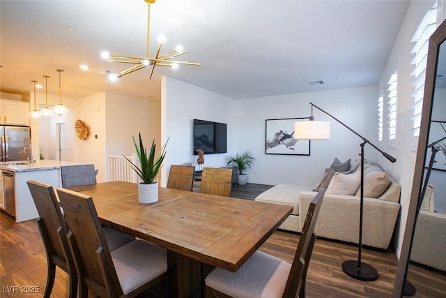 dining space featuring dark hardwood / wood-style floors and an inviting chandelier