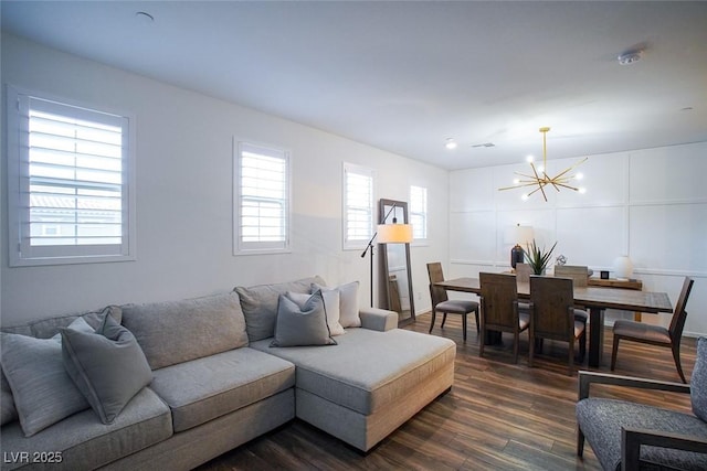 living room with dark hardwood / wood-style floors and a notable chandelier