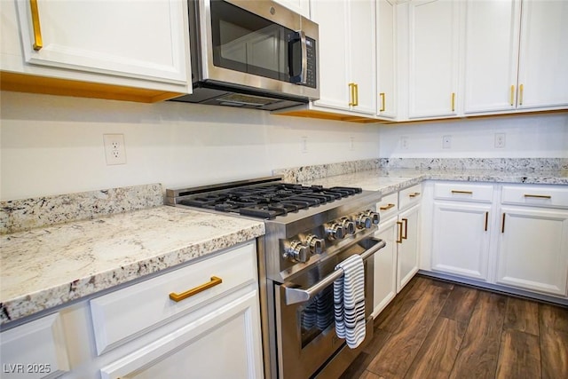 kitchen featuring light stone countertops, dark wood-type flooring, stainless steel appliances, and white cabinets