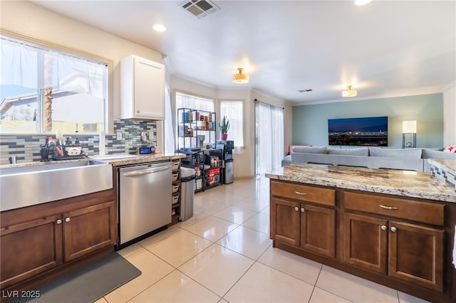 kitchen featuring stainless steel dishwasher, a wealth of natural light, sink, and backsplash