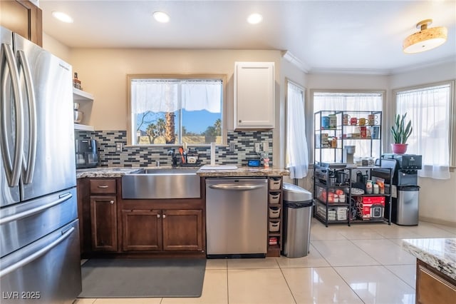 kitchen with light stone counters, appliances with stainless steel finishes, sink, and plenty of natural light