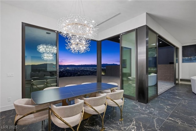 dining area with a chandelier, marble finish floor, and baseboards