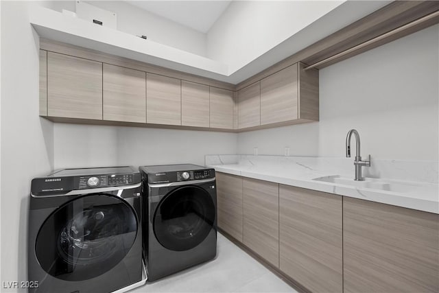 clothes washing area with washing machine and clothes dryer, a sink, and cabinet space