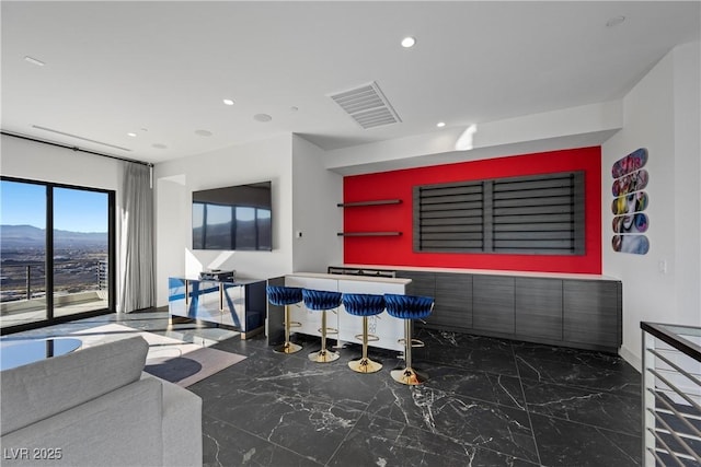 interior space featuring a mountain view, recessed lighting, visible vents, marble finish floor, and a dry bar