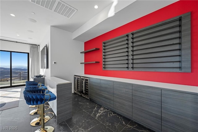 interior space with marble finish floor, visible vents, a mountain view, and recessed lighting