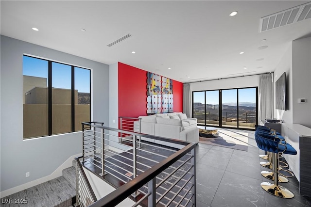 living area featuring recessed lighting, visible vents, a mountain view, and baseboards