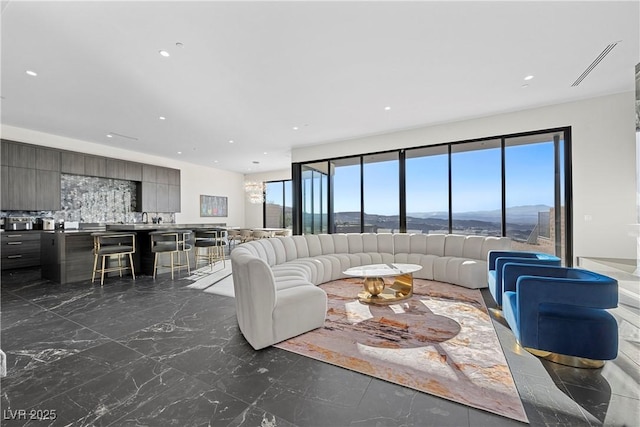 living area with recessed lighting, marble finish floor, and a mountain view