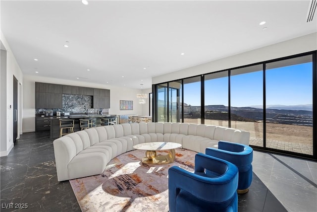 living room with a chandelier, marble finish floor, a mountain view, and recessed lighting