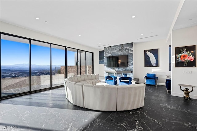 living area featuring marble finish floor, a fireplace, recessed lighting, a mountain view, and baseboards