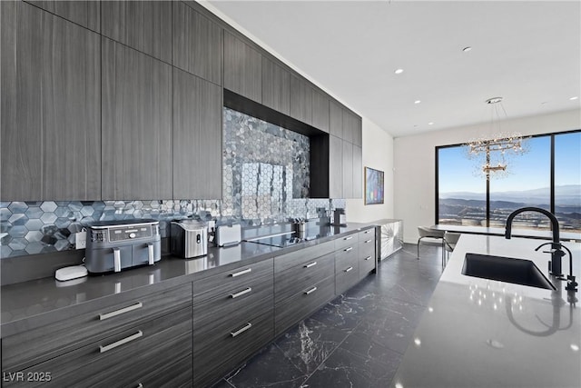 kitchen with marble finish floor, a sink, a mountain view, modern cabinets, and black electric cooktop