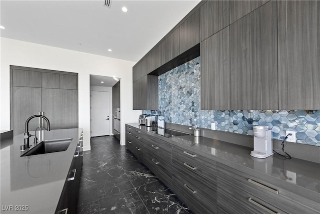 kitchen with black electric cooktop, recessed lighting, a sink, marble finish floor, and modern cabinets