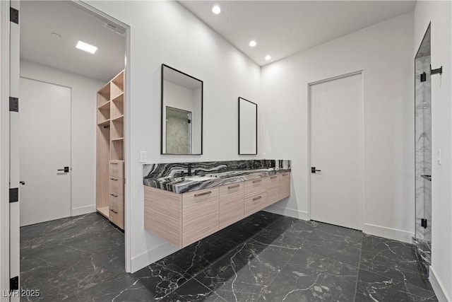 bathroom with recessed lighting, marble finish floor, and double vanity