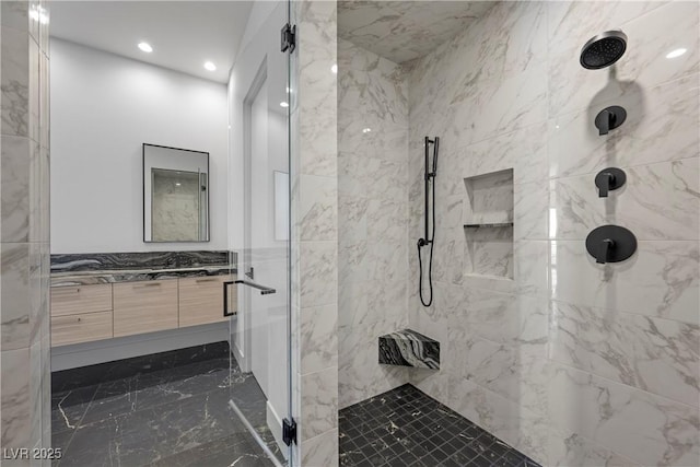 full bathroom with recessed lighting, vanity, tile walls, marble finish floor, and a stall shower