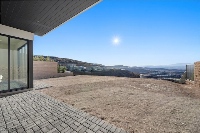 view of yard with a patio area, fence, and a mountain view