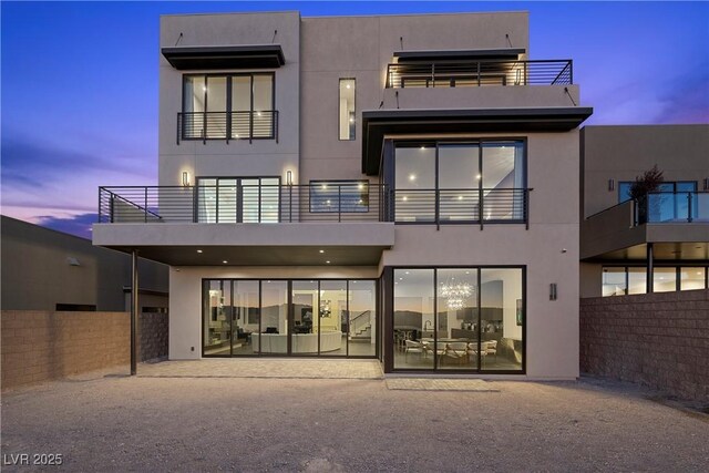 back of property with fence and stucco siding