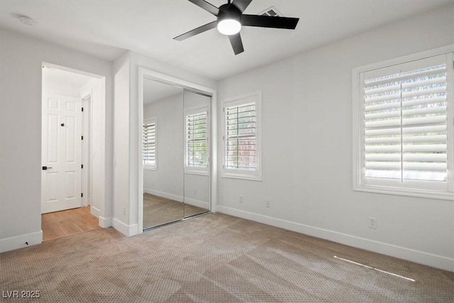 unfurnished bedroom featuring ceiling fan, light colored carpet, and a closet