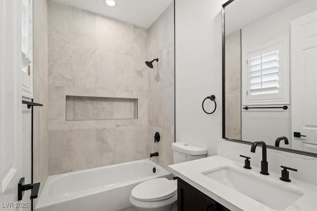 full bathroom featuring vanity, tiled shower / bath combo, and toilet