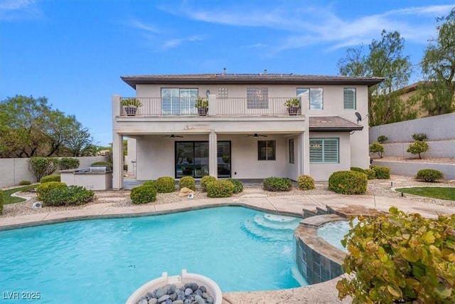 back of house featuring a fenced in pool, a patio, a balcony, and ceiling fan