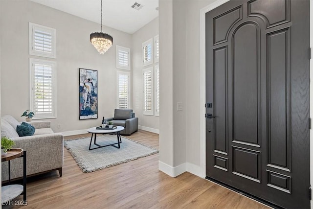 entryway featuring light hardwood / wood-style flooring and a chandelier