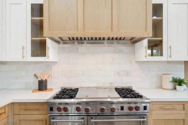 kitchen with tasteful backsplash, double oven range, light brown cabinets, and premium range hood