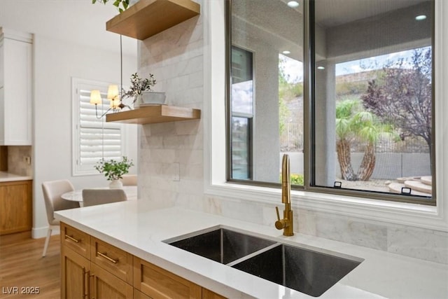 kitchen with sink, decorative light fixtures, and a healthy amount of sunlight