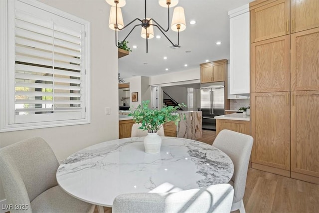 dining area with a notable chandelier and light hardwood / wood-style flooring