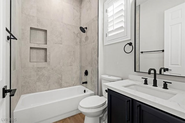 full bathroom featuring vanity, tiled shower / bath combo, toilet, and hardwood / wood-style flooring