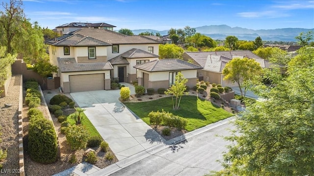 view of front of house featuring a garage, a mountain view, and a front yard