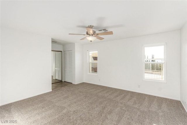 empty room featuring ceiling fan and carpet