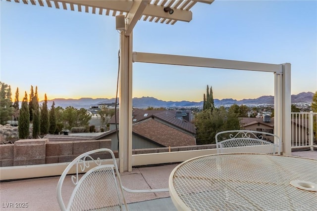 patio terrace at dusk featuring a mountain view and a pergola