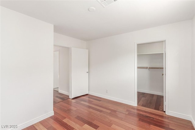 unfurnished bedroom with hardwood / wood-style flooring and a closet