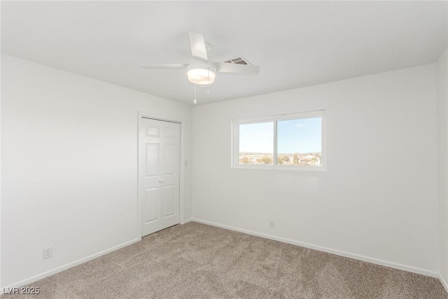 carpeted spare room featuring ceiling fan