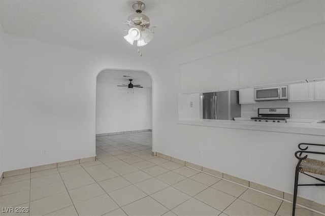 tiled spare room with ceiling fan