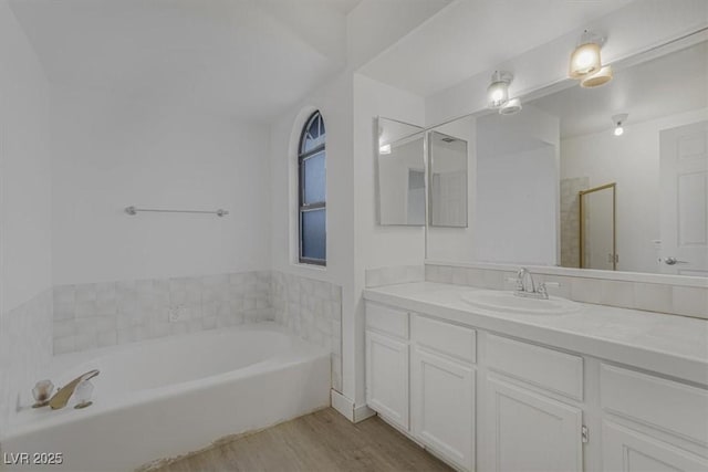 bathroom featuring hardwood / wood-style flooring, vanity, and separate shower and tub