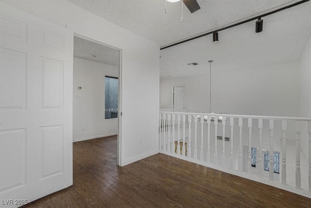 spare room featuring ceiling fan, dark hardwood / wood-style floors, and a textured ceiling