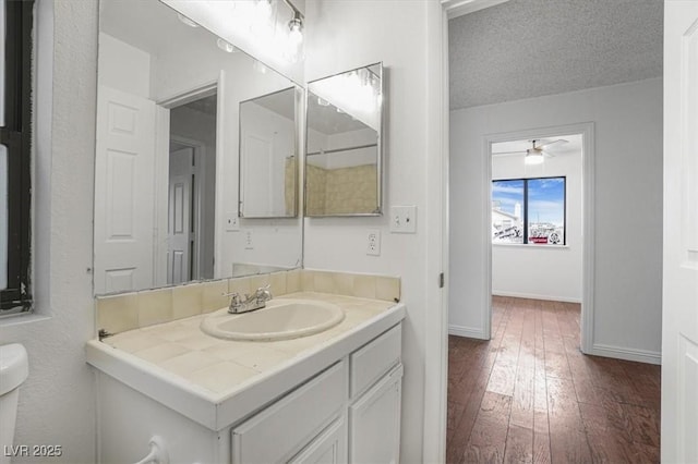 bathroom with vanity, wood-type flooring, toilet, and a textured ceiling