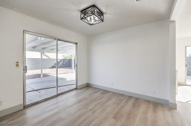 empty room featuring light hardwood / wood-style flooring and a textured ceiling