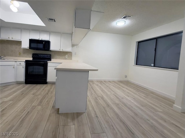 kitchen featuring black appliances, a textured ceiling, white cabinets, kitchen peninsula, and light wood-type flooring